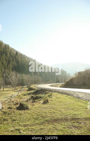 Karpatenstraße. Straße in den ukrainischen Karpaten an einem sonnigen Tag, vertikal. Karpatenstraße Stockfoto