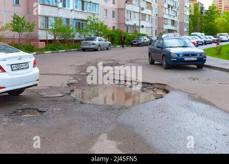 Eine Grube in der Mitte der Straße im Innenhof eines Wohnhauses Stockfoto