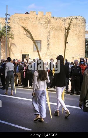 Elche, Alicante, Spanien - 10. April 2022: Menschen mit weißen Palmen zum Palmsonntag der Karwoche von Elche Stockfoto