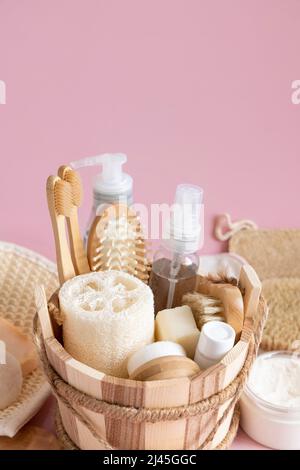 Saunaeimer mit Bio-Naturkosmetik und Zero Waste Mehrwegzubehör für Haut- und Haarpflege auf Pink. Nahaufnahme der umweltfreundlichen Kosmetikproduktion Stockfoto