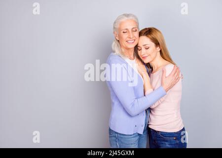 Porträt von zwei zufriedenen Menschen kuscheln geschlossenen Augen genießen Moment isoliert auf grauem Hintergrund Stockfoto