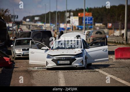 BUCHA, UKRAINE - 04. April 2022 - Ein Fahrzeug, das durch Schüsse auf der Autobahn in der Nähe von Bucha, Ukraine, beschädigt wurde. Es ist nicht klar, aus der Beschriftung geliefert, wer die Besatzung Stockfoto