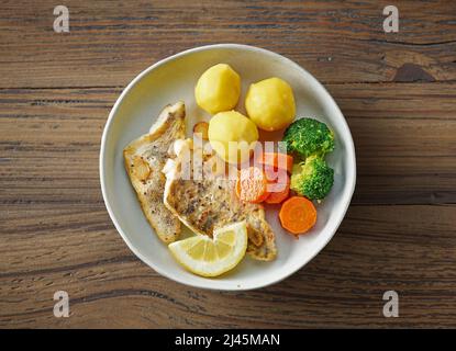 Geröstetes Zanderfilet und Gemüse auf einem hölzernen Küchentisch Stockfoto