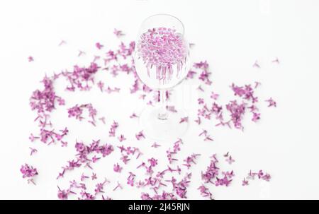 Tasse heißen Morgenkaffee und Fliederblüten auf weißem Hintergrund. Platz für Text kopieren. Konzept der Feiertage und Guten Morgen Wünsche. Stockfoto