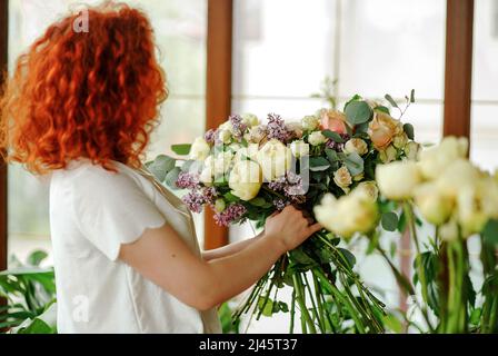 Floristin Frau schafft Blumenarrangement in einer runden Box. Schönes Bouquet von gemischten Blumen. Blumengeschäft Konzept. Schöner frischer Haufen. Stockfoto