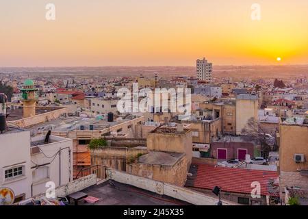 Tayibe, Israel - 09. April 2022: Sonnenuntergang Blick von der Dachterrasse auf das antike Zentrum und die Omar ibn al-Khattab Moschee in Tayibe, einer muslimischen arabischen Stadt im Zentrum von IS Stockfoto