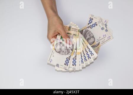 Weibliche Hände halten ukrainische Geldwährung. Mehrere tausend Griwna-Banknoten bis 500. Geld der Ukraine. Stockfoto