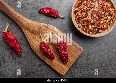 Auswahl an frischen und getrockneten Chilischoten auf rustikalem Hintergrund Stockfoto