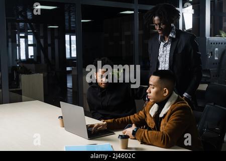 Multinationale Brainstorming-Gruppe von Kollegen, die online am Projekt im Briefing Room arbeiten. Schwarzer afrikanischer Geschäftsmann und Asian arbeiten im Team zusammen Stockfoto