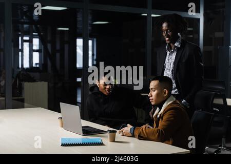 Multinationale Brainstorming-Gruppe von Kollegen, die online am Projekt im Briefing Room arbeiten. Schwarzer afrikanischer Geschäftsmann und Asian arbeiten im Team zusammen Stockfoto