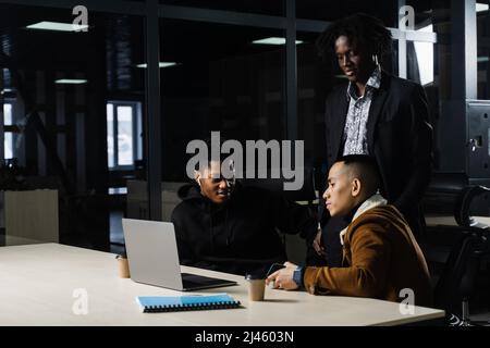 Multinationale Brainstorming-Gruppe von Kollegen, die online am Projekt im Briefing Room arbeiten. Schwarzer afrikanischer Geschäftsmann und Asian arbeiten im Team zusammen Stockfoto