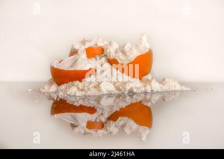 Eiweißpulverhaufen und Eierschalen mit Spiegelreflexion auf dem Tisch. Sporternährung. Stockfoto