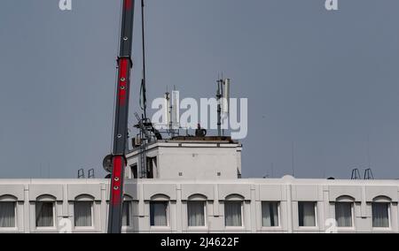 Berlin, Deutschland. 12. April 2022. Arbeiter installieren Mobilfunkantennen auf einem Hoteldach. Quelle: Paul Zinken/dpa/Alamy Live News Stockfoto