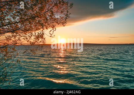 Farbenprächtiger Sonnenuntergang über dem See. Stockfoto