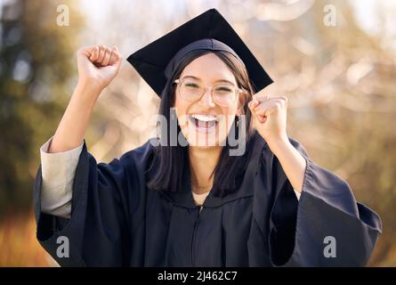 Ich kam, ich lernte, ich eroberte. Aufnahme einer jungen Frau, die am Abschlusstag jubelt. Stockfoto