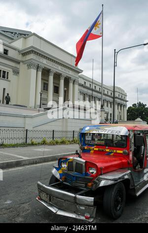 Manila, Philippinen - 2022. März: Ein Jeepney, der am 27. März 2022 in Manila, Philippinen, am National Museum of Fine Arts vorbei fährt. Stockfoto