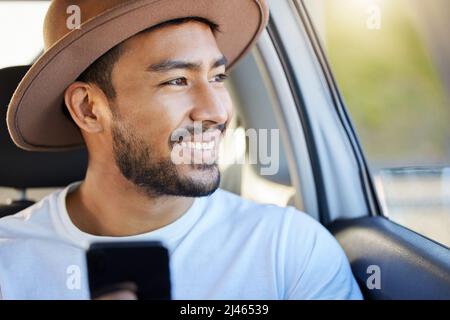 Straßen sind eine Aufzeichnung von denen, die vorher gegangen sind. Aufnahme eines jungen Mannes, der in einem Auto sitzt, während er sein Telefon benutzt. Stockfoto