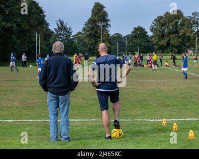 Musselburgh, Schottland, 5.. September 2021: Zwei Fußballtrainer schauen sich ein Jugendspiel an. Stockfoto