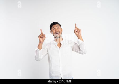 Aufgeregt asiatischen jungen Mann mit zwei Fingern zeigen nach oben Stockfoto