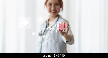 Kardiologe mit rotem Herz in Privatklinik. Medizintechnik Diagnostik von Herz-Konzept. Stockfoto