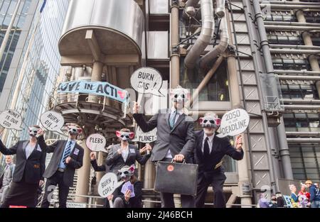 London, England, Großbritannien. 12. April 2022. Aktivisten, die als „korporative Ratten“ gekleidet sind. Extinction Rebellion-Aktivisten verursachten Chaos beim Versicherungsgiganten Lloyd's in der City of London und forderten, dass das Unternehmen die Versicherung von Projekten mit fossilen Brennstoffen einstellt. Einige Demonstranten kletterten auf das Gebäude und ließen Transparente fallen, während andere sich um das Gebäude herum klebten und verketteten. (Bild: © Vuk Valcic/ZUMA Press Wire) Stockfoto