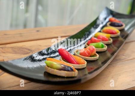 Luk Choop ist die beliebte thailändische Desserts in fruchtschnellförmigen Mungobohnen, die mit Lebensmittelfarbe gemalt werden, dann mit Gelee beschichtet. Stockfoto