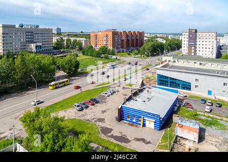 Kemerowo, Russland - 24. juni 2021. Der Verkehr der städtischen Landschaft bewegt sich in beide Richtungen, den Bau der Sparkasse und der Hypothekenbank, Stockfoto