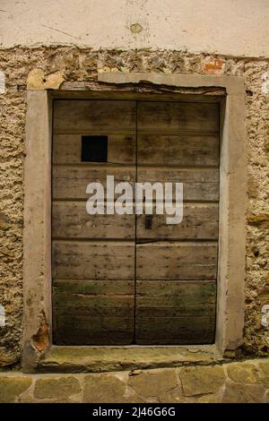 Eine alte Holztür in Poffabro, einem historischen mittelalterlichen Dorf im Val Colvera Tal in der Provinz Pordenone, Friaul-Julisch Venetien, Nordostitalien Stockfoto