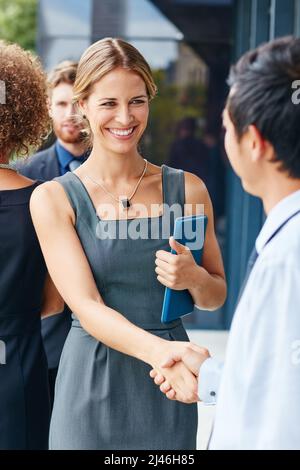 Vernetzen Sie Ihren Weg zum Erfolg. Aufnahme einer Geschäftsfrau und eines Geschäftsmannes, die sich im Freien die Hände schüttelten. Stockfoto