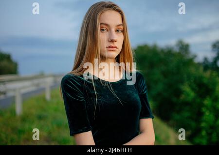 Porträt einer jungen Frau mit langen blonden Haaren in der Natur Stockfoto