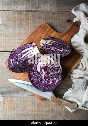 Overhead von geschnittenem Rotkohl auf einem hölzernen Schneidebrett auf dem Tisch. Stockfoto
