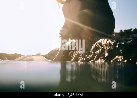 Eine Frau nimmt eine Plastiktüte aus dem Meer Stockfoto