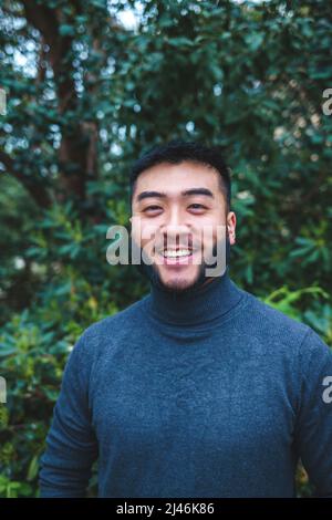 Fröhlicher bärtiger ethnischer Mann im grünen Park Stockfoto