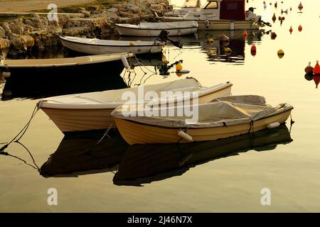 Kleiner Hafen an der ländlichen Küste mit schwimmenden Booten und Bojen zum Festmachen von Booten Stockfoto