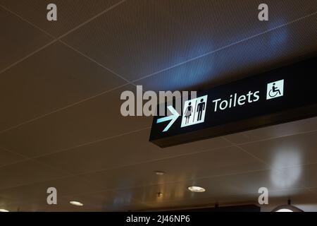 Ist die Natur ruft. Aufnahme eines Schildes, das auf ein öffentliches Badezimmer mit Rollstuhleinrichtungen in einem Gebäude hinweist. Stockfoto