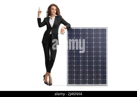 Porträt einer Geschäftsfrau, die sich auf ein Solarpanel stützt und isoliert auf weißem Hintergrund zeigt Stockfoto