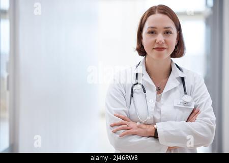 Ich liebe das, was ich jeden Tag tue. Aufnahme eines schönen jungen Arztes im Krankenhaus. Stockfoto