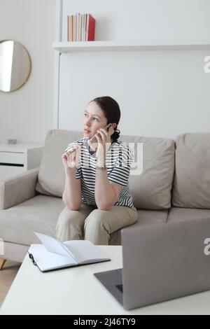 Büroleiter oder Freiberufler in einem stilvollen Raum. Selbstbewusste Geschäftsfrau, die am Arbeitsplatz in einem modernen Büro arbeitet. Büroleiter oder Freiberufler arbeiten Stockfoto