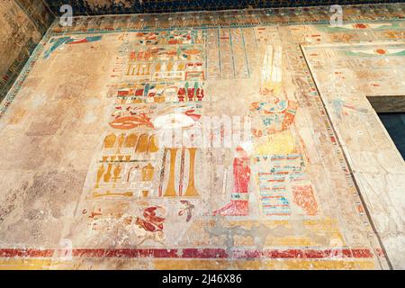 Hieroglyphen und Gemälde in Sandsteinsäulen im Hatschepsut-Tempel in Luxor geschnitzt. Ägyptisches Erbe und Zivilisationskonzept Stockfoto