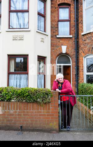 Belfast, Nordirland. 17.. März 2010. Eine Bewohnerin des Holyland-Gebiets von Belfast steht an ihrem Gartentor. Das Holyland ist ein Gebiet, das von Studenten besetzt ist und oft antisoziale Aktivitäten erfährt. Stockfoto