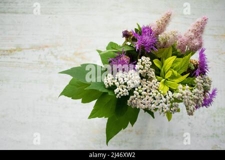 Ein Strauß wilder Blumen auf einem hölzernen Hintergrund. Rustikaler Stil. Speicherplatz kopieren. Stockfoto