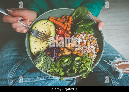 Frau, die veganes oder vegetarisches Essen isst. Vegane buddha Schüssel mit frischem Gemüse. Gesunde vegane Ernährung Stockfoto