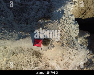 Rotes Zelt auf dem Gipfel des Berges. Niemand. Tourismus Konzept Abenteuer Reise im Freien. Camping in einem Zelt. Luftaufnahme von oben nach unten. Stockfoto