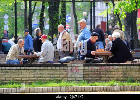 KIEW, UKRAINE - 2. MAI 2011: Nicht identifizierte ältere Menschen spielen Schach im Stadtpark. Stockfoto