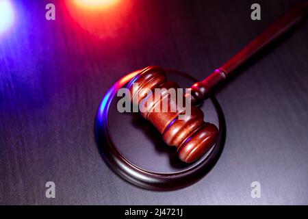 Thema „Recht“. Gerichtsverfahren in Sitzung. Richter Gavel auf Holztisch mit Polizei-Notdienst Licht. Mallet des Richters auf dunklem Hintergrund. Gerechtigkeit Menschenrechte Konzept Stockfoto