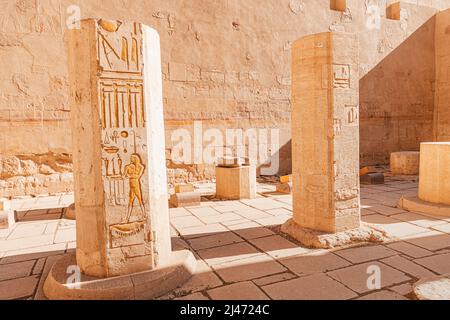 Hieroglyphen und Gemälde in Sandsteinsäulen im Hatschepsut-Tempel in Luxor geschnitzt. Ägyptisches Erbe und Zivilisationskonzept Stockfoto