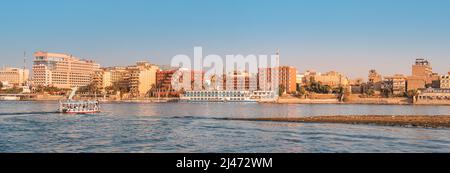 Panoramablick auf traditionelle ägyptische Fährschiffe und Kreuzschiffe auf dem Nil mit Hotels von Luxor im Hintergrund Stockfoto