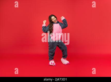 Happy erfolgreiche Teenager-Mädchen in weichen Nacht Anzug auf rotem Hintergrund, Pyjamas stehen Stockfoto