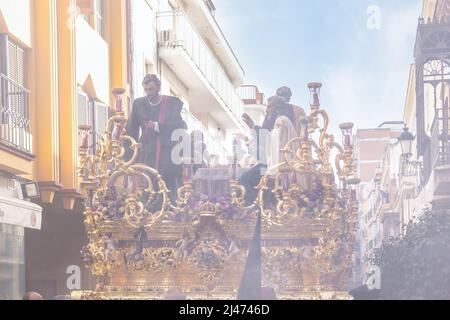 Huelva, Spanien - 10. April 2022: Prozession von La Santa Cena (das letzte Abendmahl) durch die Straßen der Stadt inmitten einer Wolke aus Räucherstäbchen während der Zeit von Hol Stockfoto