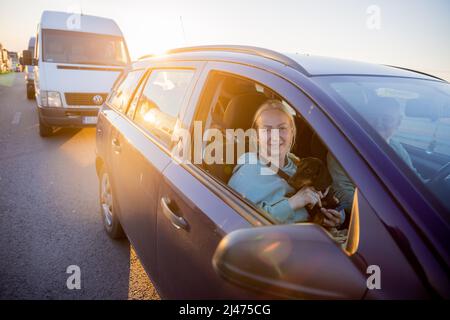 12. April 2022, Polen, Przemysl: Irina und Oleg warten mit Dackel und ihrer Tochter (nicht im Bild) auf der polnischen Seite vor dem Grenzübergang Medyka auf die Weiterreise in die Ukraine. Sie kommen aus Charkiw und wollen nun in die Ukraine zurückkehren. Als der Krieg ausbrach, floh die Familie zunächst zu Verwandten in der Nähe von Lemberg. Nach Anschlägen in der Westukraine flohen sie nach Südpolen, wo sie zweieinhalb Wochen bei Privatbürgern blieben. Jetzt wollen sie zu Verwandten in der Nähe von Lemberg zurückkehren, weil die Russen aus Charkow 'noch nicht gegangen sind'. „Natürlich wollen wir nach Hause gehen“, so der Stockfoto